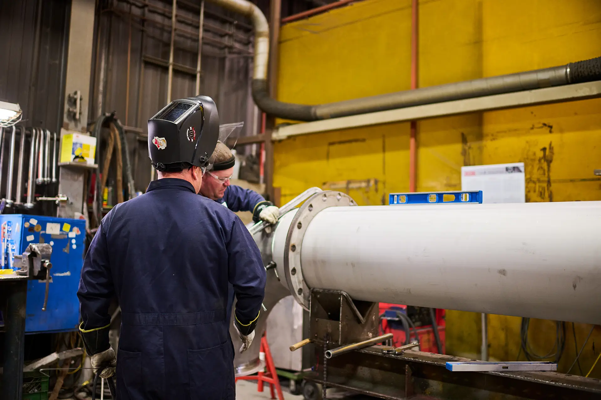 Two workers working on pipe